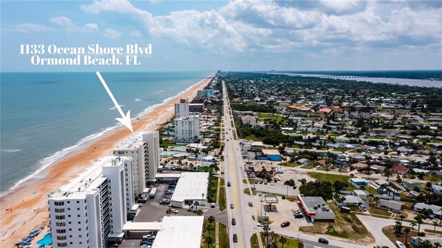 drone / aerial view with a water view and a beach view