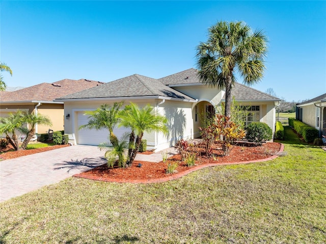 single story home featuring a garage, roof with shingles, decorative driveway, a front lawn, and stucco siding