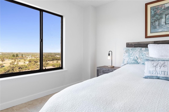 tiled bedroom featuring baseboards