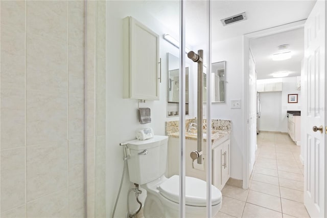 bathroom with tile patterned flooring, toilet, vanity, visible vents, and baseboards