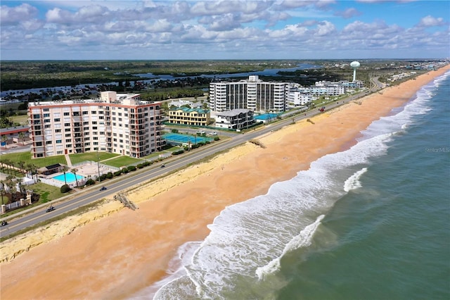 birds eye view of property featuring a water view and a beach view