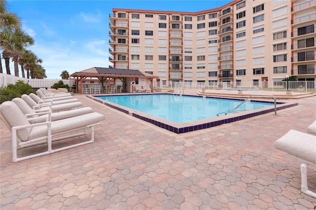 community pool with fence, a patio, and a gazebo