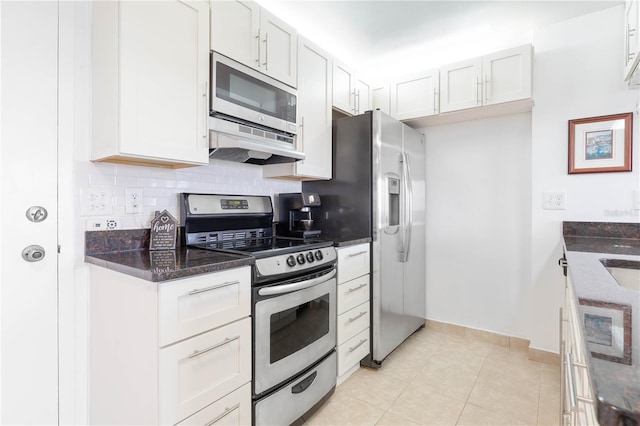 kitchen featuring under cabinet range hood, appliances with stainless steel finishes, decorative backsplash, and dark stone counters