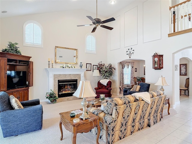 9 Cedar Hollow Ct, Palm Coast, FL 32137 - living room featuring arched walkways, a glass covered fireplace, a ceiling fan, and plenty of natural light