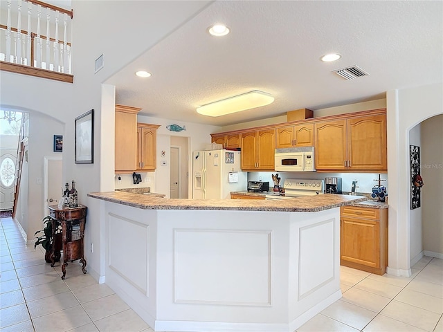 9 Cedar Hollow Ct, Palm Coast, FL 32137 - kitchen with visible vents, a peninsula, white appliances, recessed lighting, and arched walkways