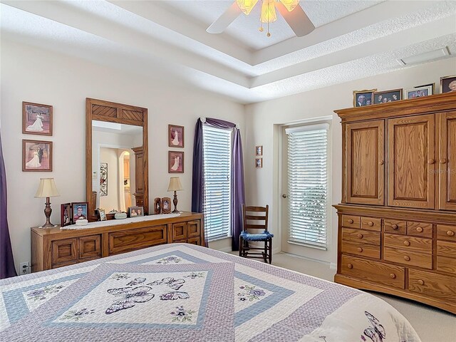 9 Cedar Hollow Ct, Palm Coast, FL 32137 - bedroom featuring a tray ceiling, a textured ceiling, arched walkways, access to exterior, and a ceiling fan