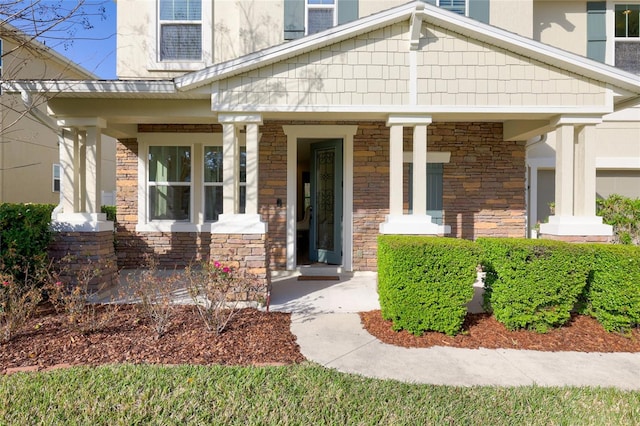 entrance to property featuring stone siding and covered porch