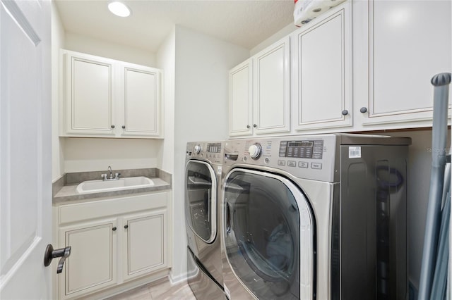 laundry room with recessed lighting, cabinet space, independent washer and dryer, and a sink