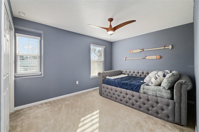 bedroom featuring a textured ceiling, a ceiling fan, baseboards, and carpet floors