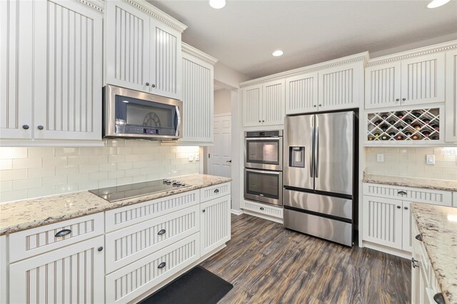 kitchen featuring backsplash, light stone countertops, recessed lighting, appliances with stainless steel finishes, and dark wood-style floors