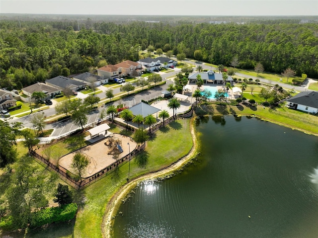 birds eye view of property featuring a forest view and a water view