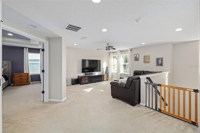 living room featuring baseboards, visible vents, recessed lighting, a textured ceiling, and carpet flooring