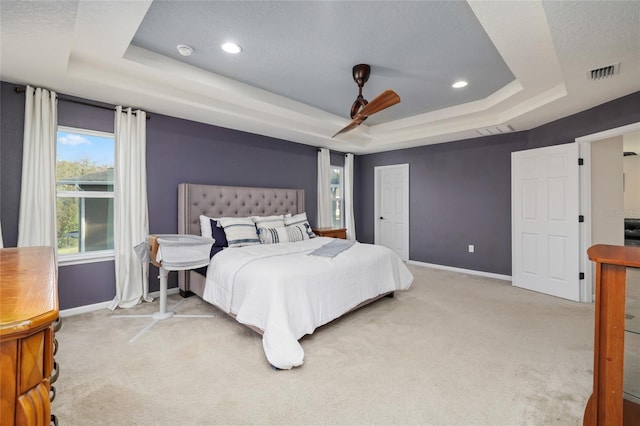 bedroom featuring visible vents, baseboards, carpet, and a tray ceiling