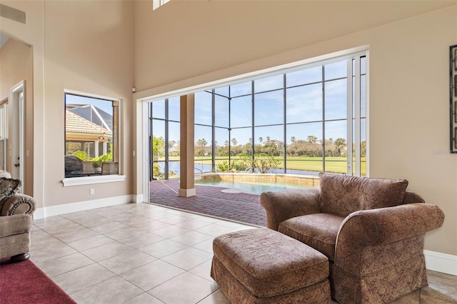 interior space with a high ceiling, baseboards, and visible vents