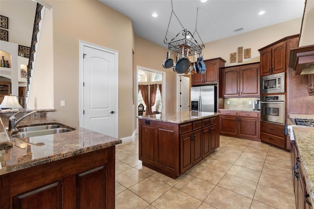 kitchen featuring backsplash, a sink, light tile patterned flooring, light stone counters, and appliances with stainless steel finishes