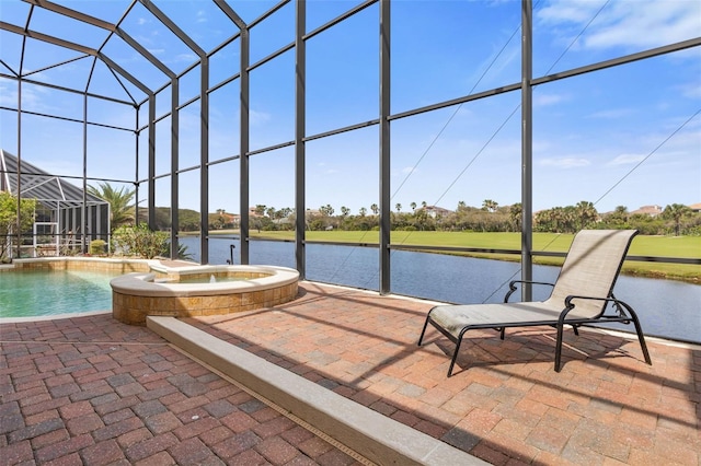 exterior space with glass enclosure, a pool with connected hot tub, and a water view