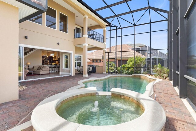 view of swimming pool featuring an outdoor hangout area, a pool with connected hot tub, a lanai, and a patio