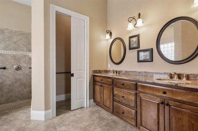 bathroom with double vanity, a walk in shower, a sink, and tile patterned floors