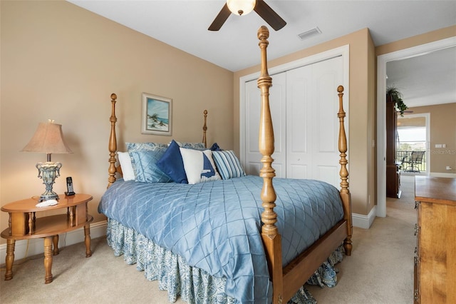 bedroom with a closet, visible vents, baseboards, ceiling fan, and light colored carpet