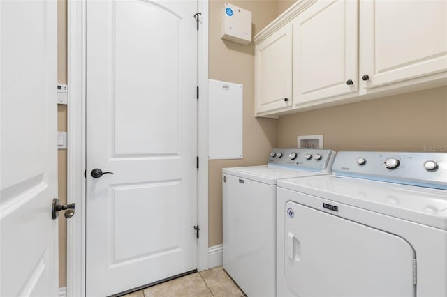 laundry room featuring light tile patterned floors, washer and clothes dryer, and cabinet space