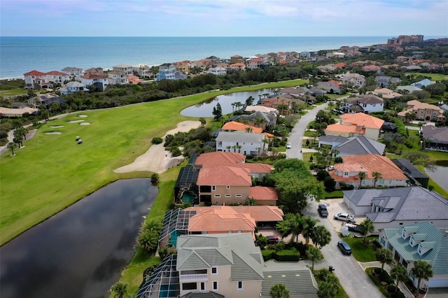 bird's eye view with golf course view, a water view, and a residential view