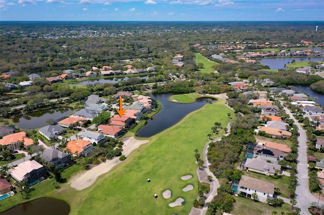 drone / aerial view with view of golf course, a residential view, and a water view