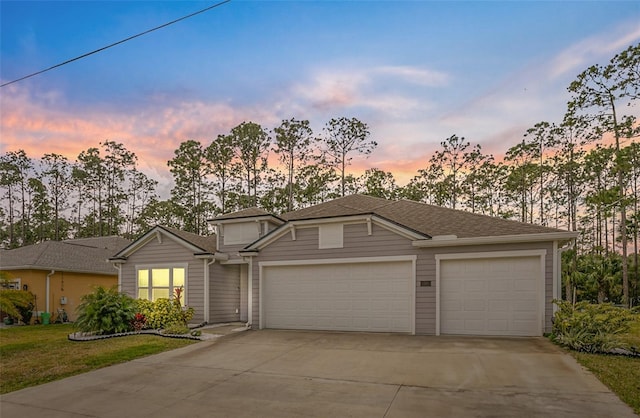 view of front of property with driveway, an attached garage, a front lawn, and a shingled roof