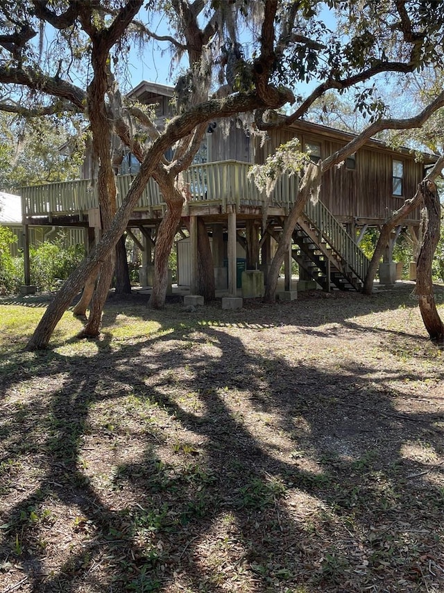 rear view of property with stairs and a deck