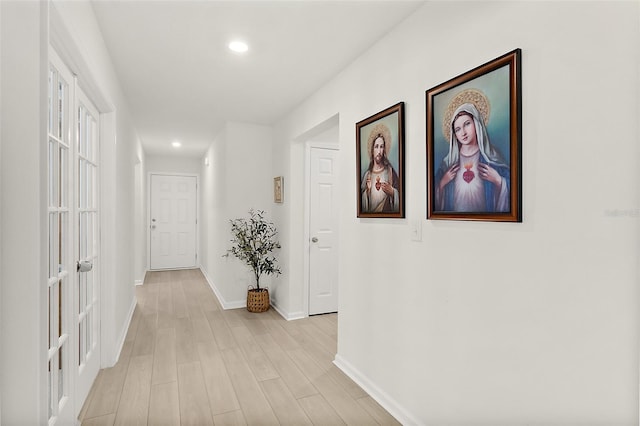 hallway featuring light wood-style floors, recessed lighting, and baseboards