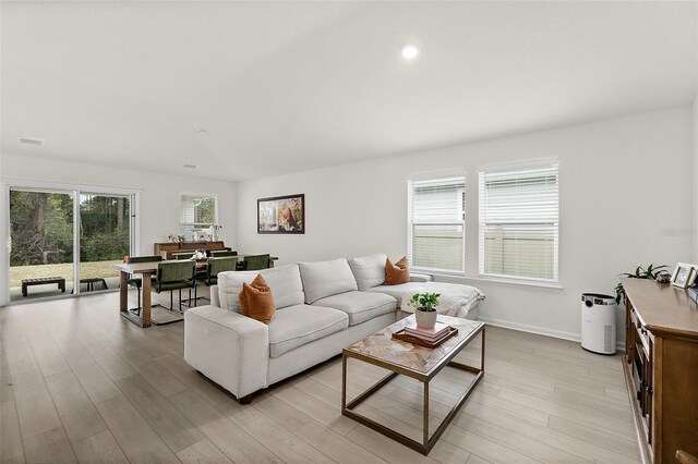 living room featuring light wood finished floors, baseboards, visible vents, and recessed lighting