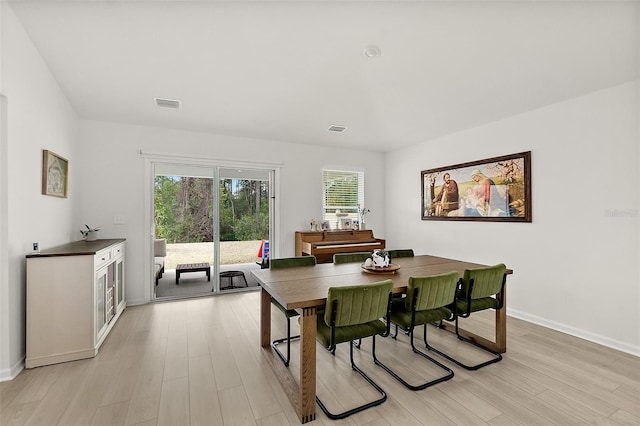 dining area featuring light wood-type flooring, baseboards, and visible vents