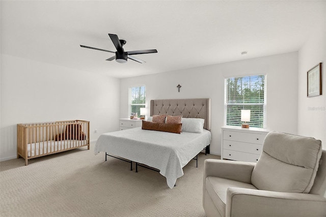 bedroom featuring a ceiling fan, light carpet, and baseboards