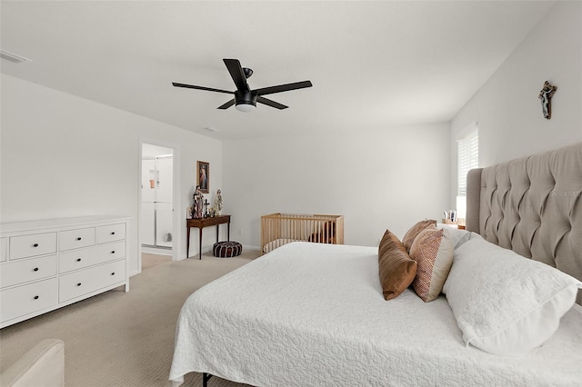 bedroom featuring a ceiling fan, light carpet, visible vents, and ensuite bathroom