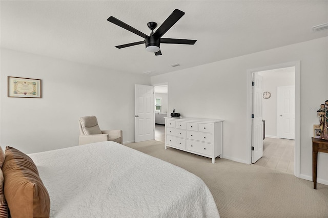 bedroom featuring light colored carpet, ceiling fan, visible vents, and baseboards