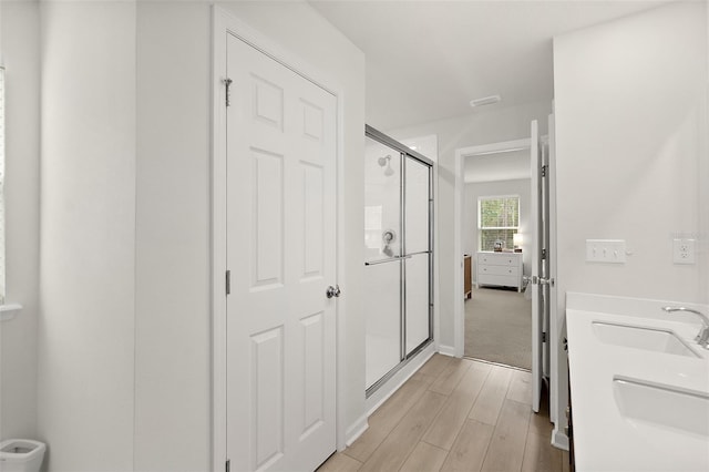 corridor featuring light wood-type flooring and a sink