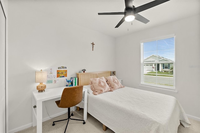 bedroom featuring light colored carpet, ceiling fan, and baseboards