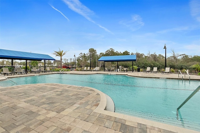 community pool with a patio and fence