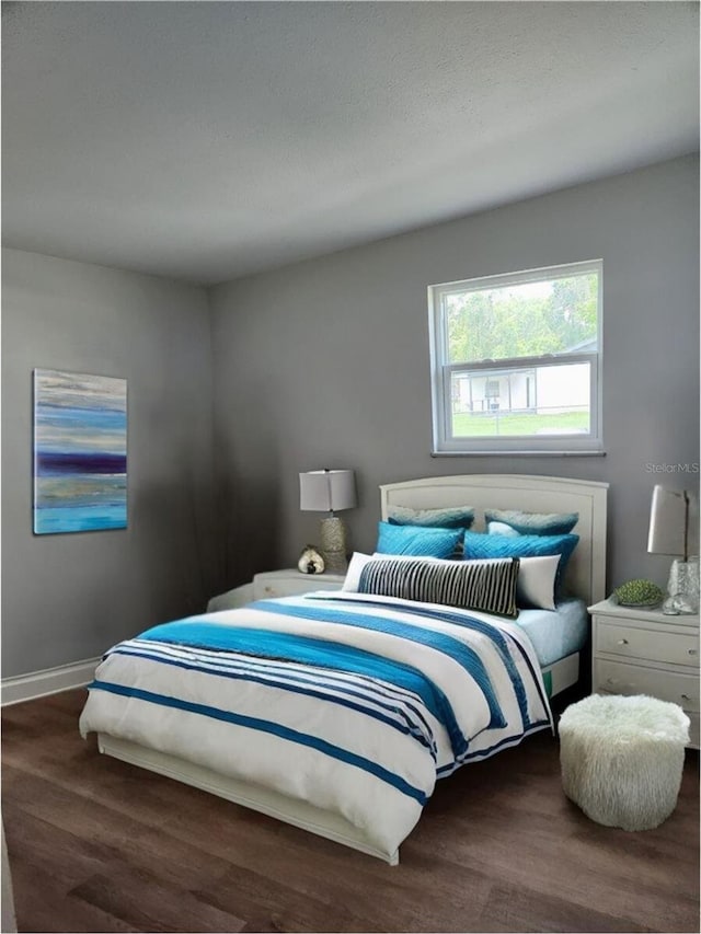 bedroom with wood finished floors and baseboards