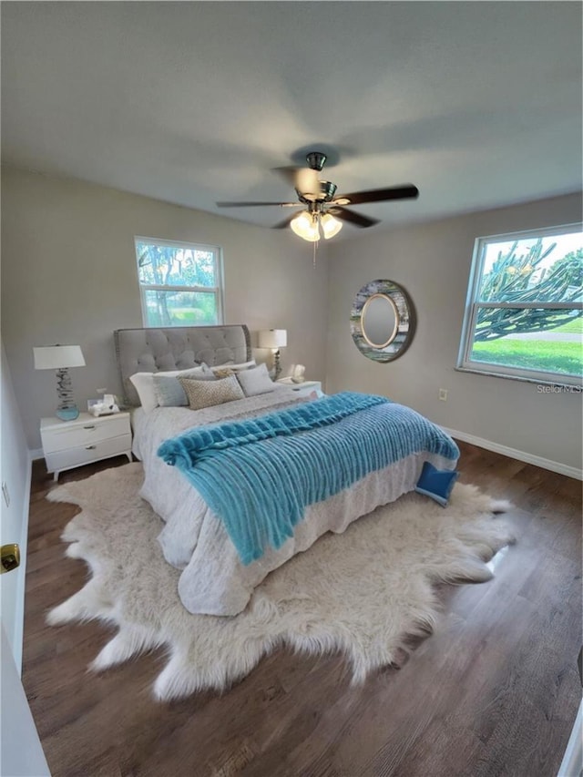 bedroom with wood finished floors, a ceiling fan, and baseboards