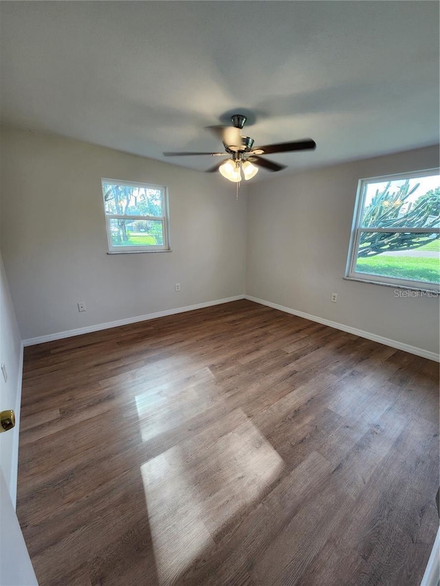 empty room with ceiling fan, baseboards, and wood finished floors