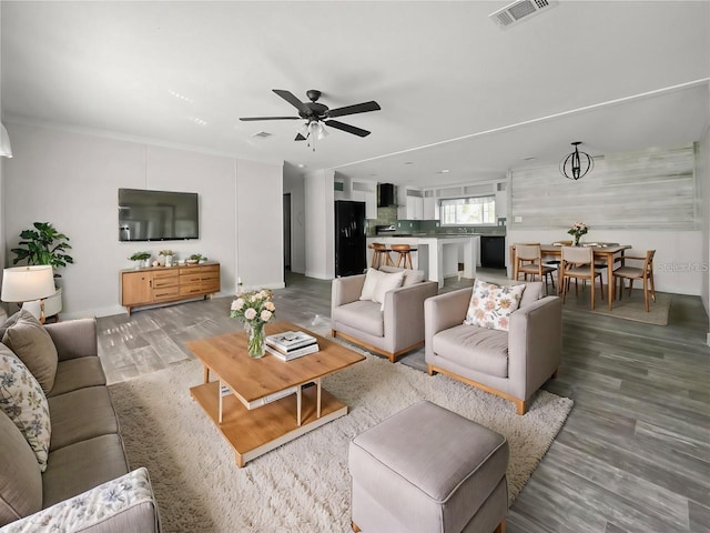 living area featuring a ceiling fan, visible vents, and light wood-style floors