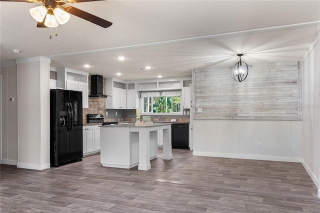 kitchen featuring black appliances, wall chimney exhaust hood, white cabinets, and backsplash