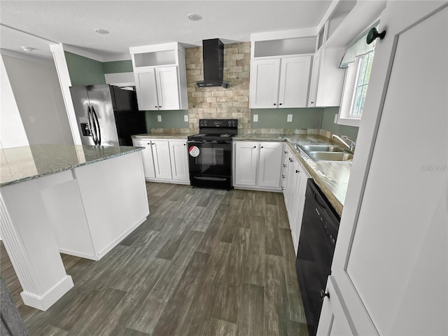 kitchen featuring dark wood finished floors, white cabinets, a sink, wall chimney range hood, and black appliances