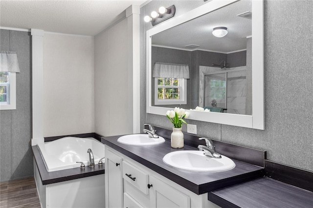 bathroom featuring a stall shower, a garden tub, a sink, and wood finished floors