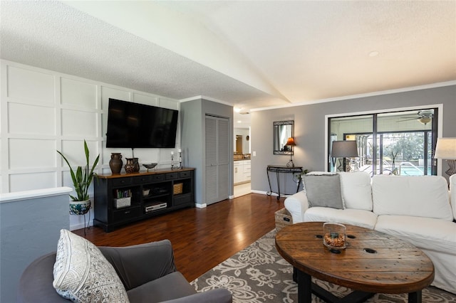 living area featuring baseboards, a textured ceiling, wood finished floors, and crown molding