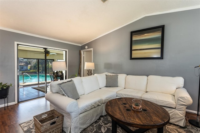 living room featuring baseboards, wood finished floors, crown molding, and vaulted ceiling