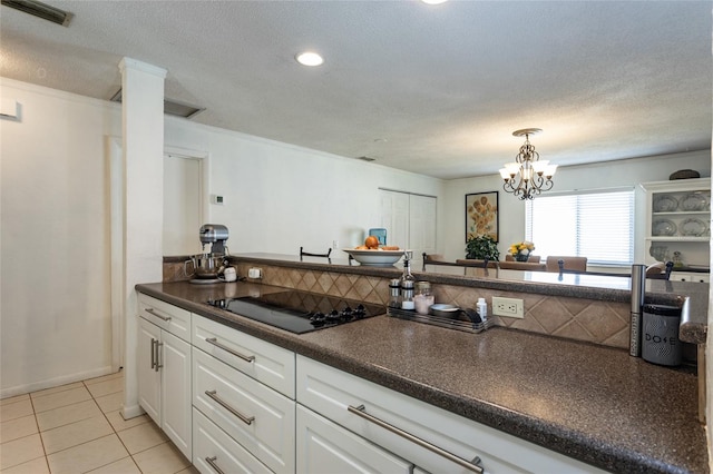 kitchen with dark countertops, visible vents, black electric stovetop, light tile patterned floors, and white cabinets