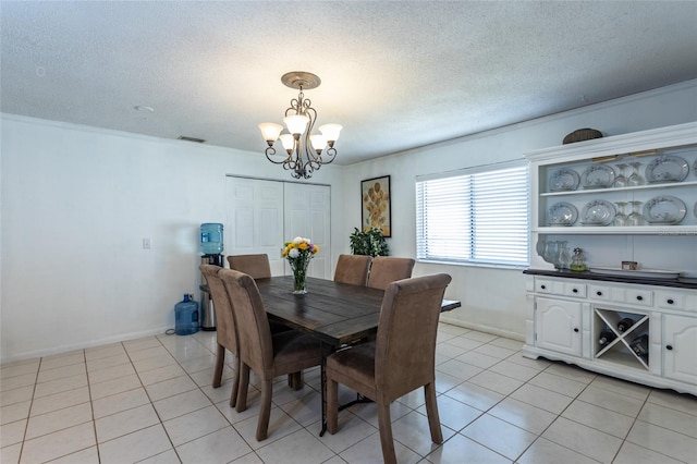 dining area featuring light tile patterned flooring, a notable chandelier, a textured ceiling, and visible vents