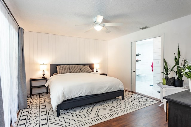 bedroom with visible vents, ceiling fan, light wood-type flooring, a textured ceiling, and ensuite bath