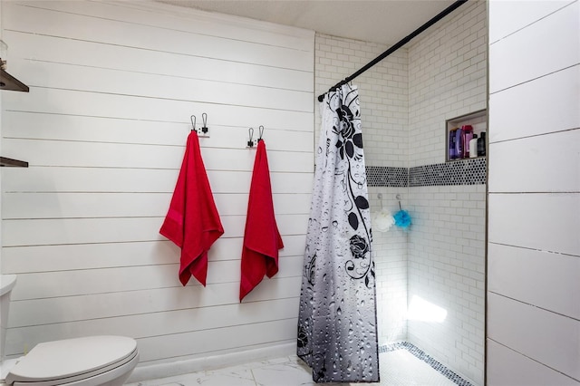 full bath with tiled shower, toilet, and marble finish floor